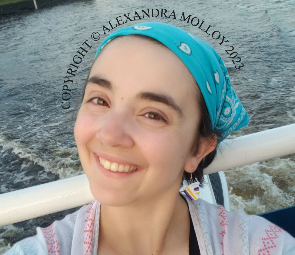 "Selfie of the blog owner Alexandra Molloy smiling on a boat, with river water in the background."